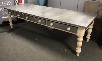 A massive painted pine zinc topped kitchen table, with three drawers, on heavy turned legs, 275x96.5