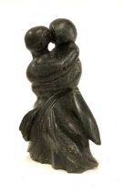 A carved stone figure of an embracing couple, 36cmH