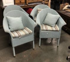 A set of four Vincent Sheppard Lloyd Loom wicker armchairs, painted pale blue with matching circular
