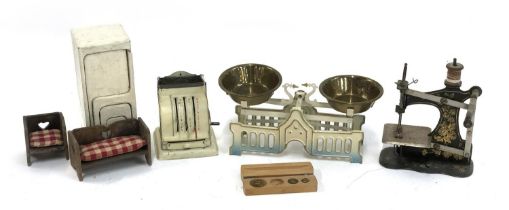 A miniature toy sewing machine; toy kitchen scales; shop till; tessellating dolls house chairs and
