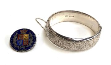 A silver bangle with engraved foliate design, hallmarked for Walker & Hall, Birmingham, 1958 28g;