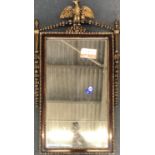 A decorative giltwood wall mirror with eagle cresting, of recent manufacture, 98x55cm