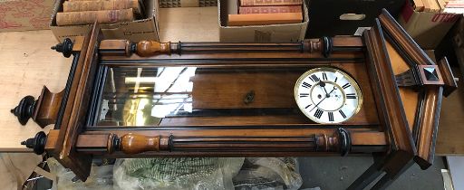 A regulator wall clock, architectural pediment, enamel dial with Roman numerals, flanked by columns,