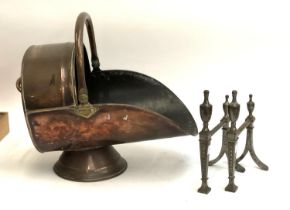 A pair of polished steel Adam style fire dogs, 27cmH; together with a copper coal scuttle