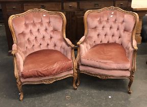 A pair of Louis XV style continental button back armchairs, with carved frames