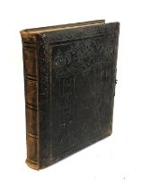 A partly-filled Victorian photograph album in heavily embossed tooled leather binding. The 'Forget-