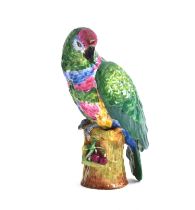 A porcelain figure of a parrot perched upon a stump, blue crossed sword marks to base, 26.5cm high