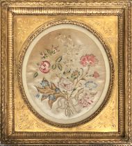 A 19th century silkwork depicting a stand of flowers, in an oval mount, 33x29cm