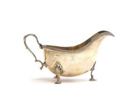 A silver sauce boat by Walker & Hall, Sheffield 1948, silver gilt interior, gadrooned rim, on