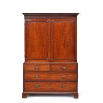A George III mahogany linen press, dentil cornice over well figured doors opening to a hanging rail,
