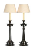 A pair of patinated metal table lamps, each with shade above a simulated candle and 'pricket'