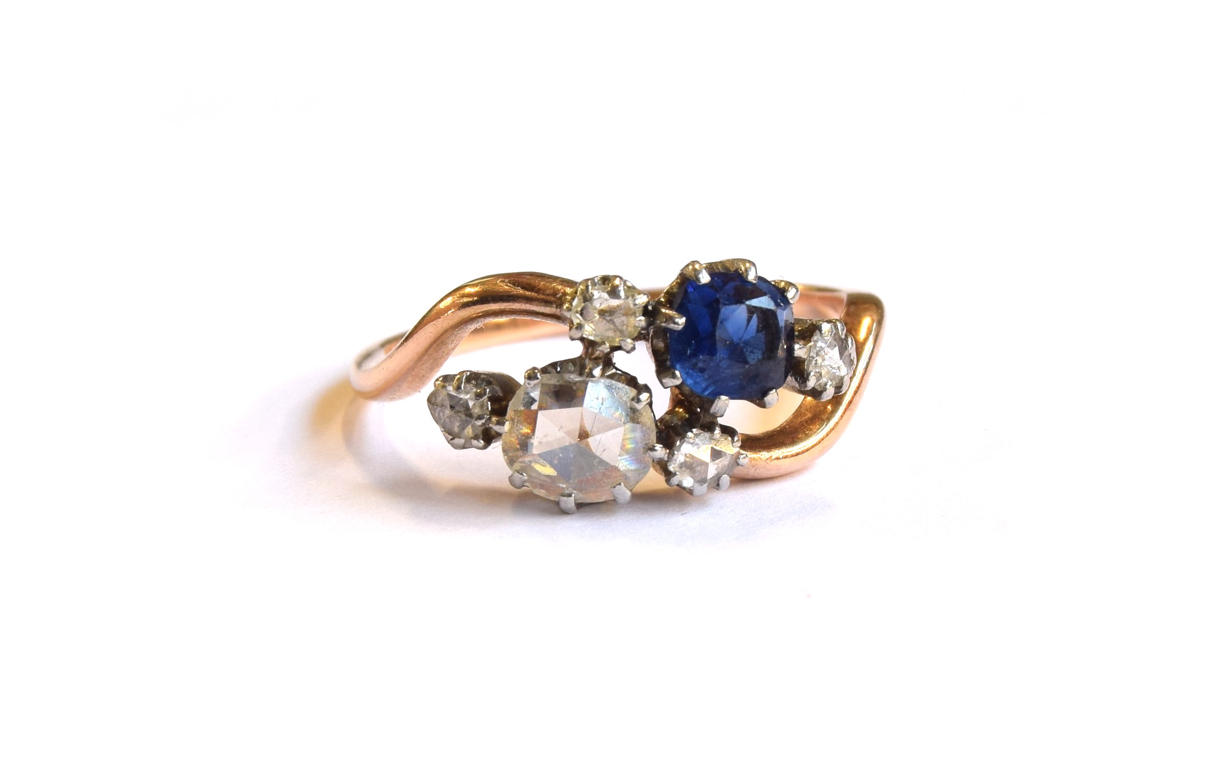 An early 20th century 18ct gold 'Toi et Moi' diamond and sapphire crossover ring, the large rose cut