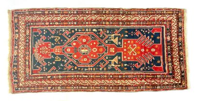A red ground tribal rug, 323x150cm