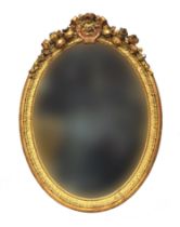 A 19th century gilt wood and gesso oval mirror, with floral cresting, 83cm wide, 115cm high