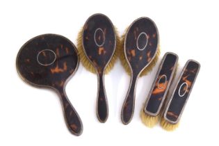 A silver and tortoiseshell dressing table set, comprising a pair of clothes brushes, a pair of