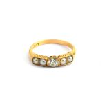 A Victorian 18ct gold ring set with a central old cut diamond flanked by two pearls on each