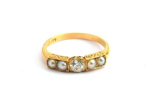 A Victorian 18ct gold ring set with a central old cut diamond flanked by two pearls on each