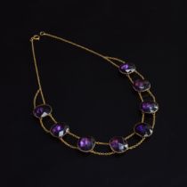 An 18th century 'Queen Anne' amethyst paste riviere necklace, the eight rose cut paste stones each