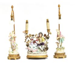 A 19th century porcelain figure group, mounted as a table lamp on a gilt metal base, with two