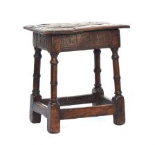 A 17th century oak joint stool, the moulded seat raised on ring turned supports joined by peripheral