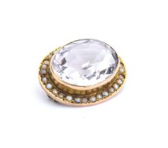 A Victorian yellow metal mounted rock crystal brooch surrounded by seed pearls, 2.5cm wide, gross