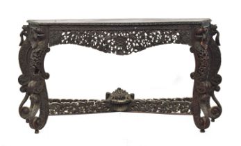 An Anglo-Indian hardwood serpentine console table, profusely carved with foliage and lion masks, the