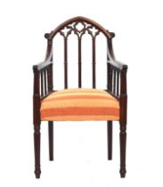 A 19th century mahogany gothic open armchair in the manner of James Wyatt, the top rail as a gothic