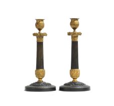 A pair of 19th century French patinated bronze and ormolu mounted candlesticks, the gilded drip