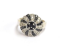 A 14ct white gold ring set with white and black diamonds in swirl design, total carat weight approx.