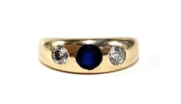 A gold gypsy ring set with diamonds and a central sapphire, marks rubbed but tests as 14ct or