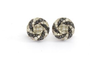 A pair of 18ct white gold Oliva earrings set with black and white diamonds in a swirl design,