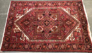 A red ground rug with central serrated lozenge, 300x200cm