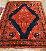 A large brick red and indigo rug, 384x290cm