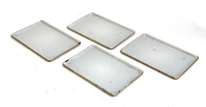 A set of four early 20th century small enamel trays with gilt rim, each 22.5x15cm
