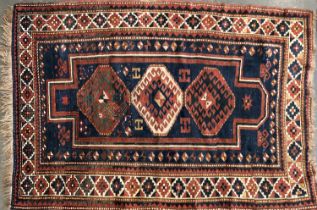 A blue ground tribal rug with three serrated lozenges, 191x134cm