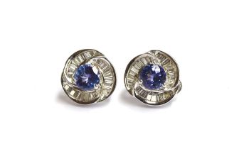 A pair of heavy 18ct white gold earrings set with a central tanzanite, 6.5mm diameter, surrounded by