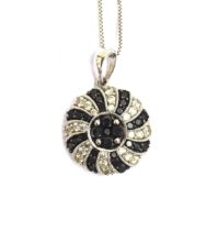 A 14ct white gold pendant set with black and white diamonds in a swirl design, 15cm diameter, on a