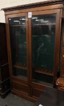 A late 19th/early 20th century mahogany glazed gun cabinet, with a fitted green baise interior, over