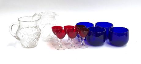 Two cut glass water jugs; a set of six cranberry sherry glasses; and four Bristol blue glass