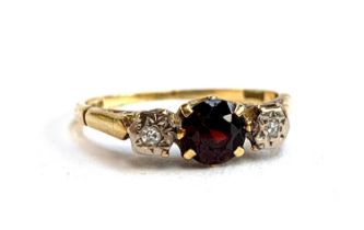 An 18ct gold, diamond and garnet trilogy ring, size M, 2.4g