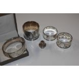 A silver snap bangle; three silver napkin rings; a