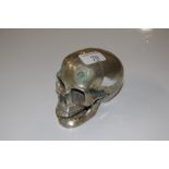 A plated metal ornament in the form of a skull