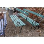 A wooden and metal garden bench with scroll arms