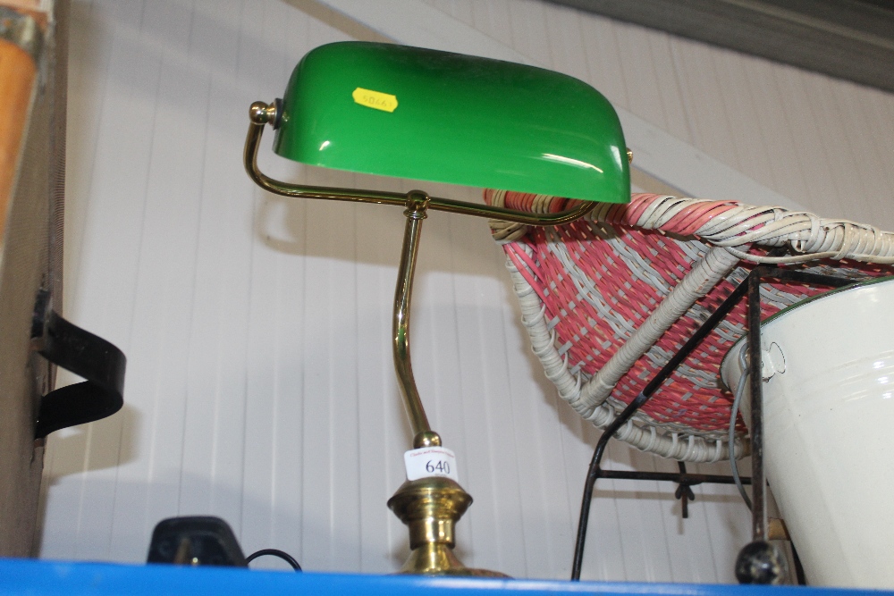 A brass desk lamp with green glass shade