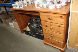 A modern pine kneehole desk fitted four drawers