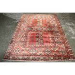 An approx 7'10" x 5'7" red and blue patterned rug