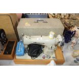 A Gamages electric sewing machine in fitted case,