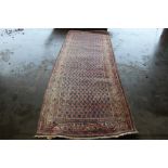 An approx 10'4" x 3'9" red and blue patterned rug