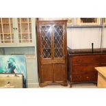 An oak corner cupboard with leaded glazed doors