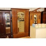 An Edwardian mahogany mirror door wardrobe fitted